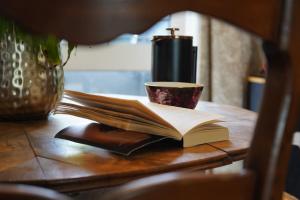 an open book on a table with a cup of coffee at Kiltumper Lodge in Kilmihil