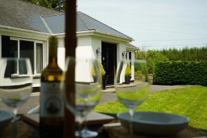 two wine glasses sitting on a table in front of a house at Kiltumper Lodge in Kilmihil