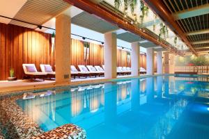 a swimming pool with chairs in a hotel at Lucky Bansko Aparthotel SPA & Relax in Bansko