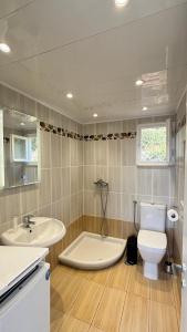 a bathroom with a tub and a toilet and a sink at Folini House in Magaziá