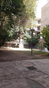 a street light in a park with a building at Private room with bathroom in Mendoza