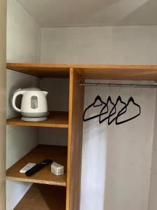 a shelf in a kitchen with a toaster and shoes at Private room with bathroom in Mendoza