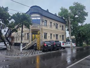 an old building with cars parked in front of it at Turg'unTown in Toshkent-Passajir Bekati
