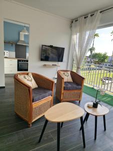 two wicker chairs and a table in a living room at Amandine - Vue mer Pointe-à-Pitre in Pointe-à-Pitre