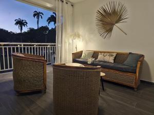a living room with a couch and two chairs at Amandine - Vue mer Pointe-à-Pitre in Pointe-à-Pitre