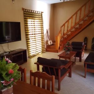 a living room with a television and a staircase at Keur Diédhiou in Saly Portudal
