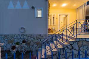 a staircase in a house with a stone wall at Μπλε Rooms & Apartments in Chiliadou