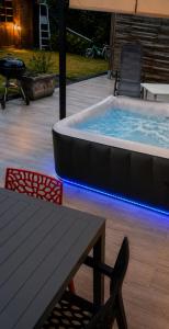 a hot tub in a patio with a table and chairs at Maison de charme avec Jacuzzi privé in Sarcelles