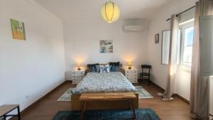 a bedroom with a bed and two chairs and a window at Alentejo Colours Cano in Cano