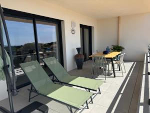 a patio with chairs and a table on a balcony at Cosi Horizon in Grosseto-Prugna