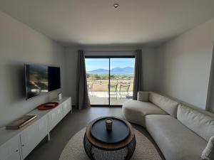 a living room with a couch and a tv at Cosi Horizon in Grosseto-Prugna