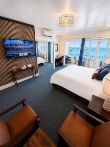 a hotel room with a large bed and a television at The Edgewater in Avalon +35 photos