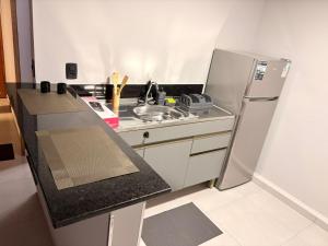 a small kitchen with a sink and a refrigerator at Hotel Santo Antonio in Botucatu