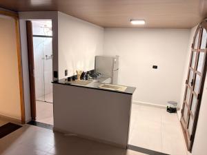a kitchen with a sink and a refrigerator at Hotel Santo Antonio in Botucatu