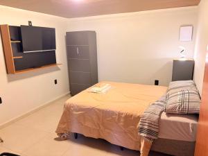 a bedroom with a bed and a flat screen tv at Hotel Santo Antonio in Botucatu