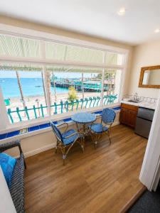 a living room with a table and chairs and a view of the beach at The Edgewater in Avalon