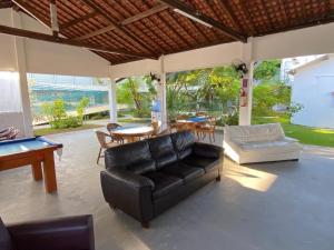 a living room with a black leather couch and a table at Pousada Costa Azul in Paulista