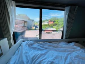 a bed in a room with a large window at Cafe&Stay Stella in Minakami