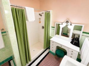 a bathroom with a green shower curtain and a sink at The Edgewater in Avalon