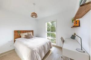 a white bedroom with a bed and a window at Villa entre Viñas in Lavid +31 photos