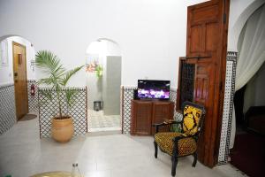 a living room with a chair and a tv at Dar Mhani in Salé