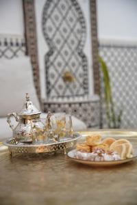 a plate of food and a tea kettle on a table at Dar Mhani in Salé +24 photos