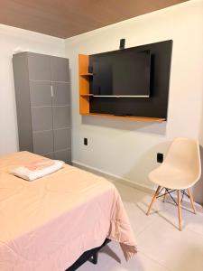 a bedroom with a bed and a tv on the wall at Hotel Santo Antonio in Botucatu +4 photos