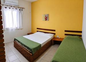 a bedroom with two beds and a window at Refugio e Fortaleza in Ubatuba +36 photos