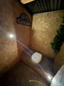 a toilet in a bathroom with a sign on the wall at Harbour view Tree House in Cobh