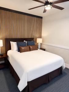 a bedroom with a large white bed with a ceiling fan at The Edgewater in Avalon