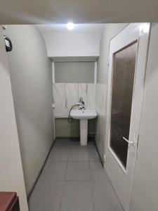 a small bathroom with a sink and a door at MG guest house in Geghanist