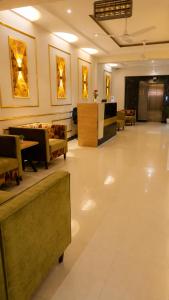 a lobby with a waiting room with tables and chairs at We Hotels Islamabad Airport in Islamabad
