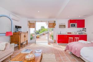 a bedroom with a bed and a kitchen with red cabinets at "The Chill Pad In Cotobro A Boutique Style Studio Where Chillin Is Easy" in Almuñécar