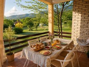 a wooden table with a bowl of food on a porch at Green Little Cottage with Pool near Ostrog Monastery in Danilovgrad