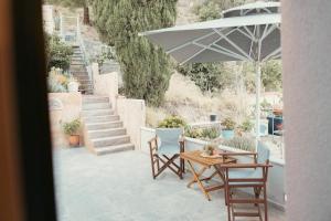 a patio with a table and chairs and an umbrella at Paul's Horizon in Chios