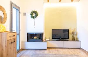 a living room with a fireplace and a tv at Paul's Horizon in Chios