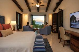 a hotel room with a bed and two people sitting in chairs at Luxury Oceanview Penthouse in HDM in Punta Mita