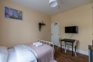 a bedroom with a bed and a desk and a television at Clare - Double Room 20 mins walk to centre -Kitchenette Smart TV Shared bathroom in Chesterton