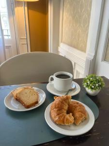 a table with two plates of pastries and a cup of coffee at Casa Chemin in Buenos Aires