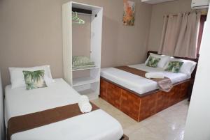 a small room with two beds and a mirror at Hotel Lua y Origenes Santa Marta in Santa Marta +11 photos