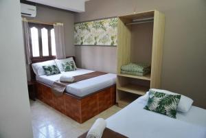 a small bedroom with two beds and a window at Hotel Lua y Origenes Santa Marta in Santa Marta