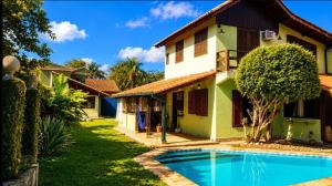 a house with a swimming pool in front of it at Casa da Jabuticaba! in Itatiaia