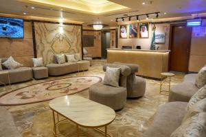 a lobby with couches and chairs and a bar at فندق بالم بوتيك مكة in Az Zahrāʼ