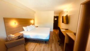 a hotel room with a bed and a desk at Econo Lodge Airport Quebec in Quebec City
