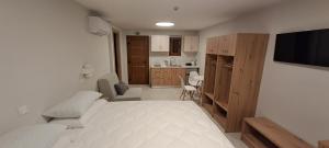 a white room with a bed and a kitchen at Calm And Nature in Petra
