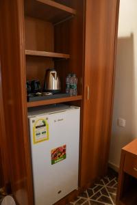 a small kitchen with a refrigerator and a shelf at فندق بالم بوتيك مكة in Az Zahrāʼ