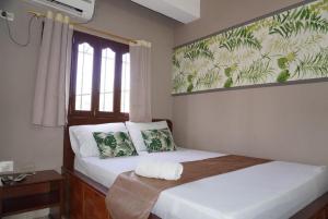 a bedroom with two beds and a window at Hotel Lua y Origenes Santa Marta in Santa Marta