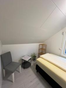 a bedroom with a bed and a chair and a window at Great Guest House Natalie's in Skjervøy