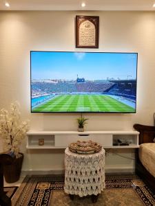 ein Flachbildfernseher, der an einer Wand im Wohnzimmer hängt in der Unterkunft Confort Flat in Salé