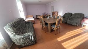 a living room with a wooden table and chairs at Guest House DEDA TINA in Mestia